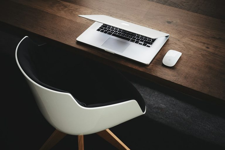 A laptop and mouse on a tidy office desk